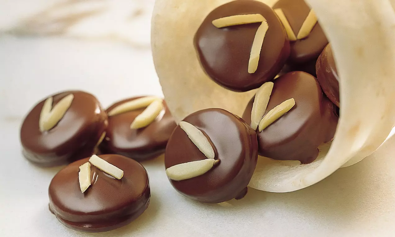 Runde Kekse mit Marmelade gefüllt und mit Kakaoglasur überzogen.