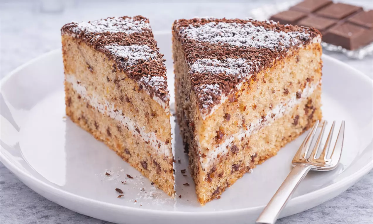 Saftiger Schokokuchen aus feiner Spezialmasse mit zart schmelzenden Schokostückchen, verfeinert mit einem Hauch Rum.